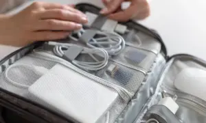 Pakowanie elektroniki do podróży. Czy powerbanki o dużej pojemności można przewozić w samolocie? W torbie znajdują się kable, ładowarki i powerbanki.