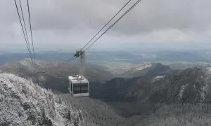 Kolejka linowa wjeżdża na ośnieżony Kasprowy Wierch, widok na góry i dolinę.