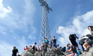 Turyści pod krzyżem na Giewoncie. Zastanawiasz się, ile waży krzyż na Giewoncie? To imponująca konstrukcja!