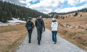 Trzy osoby idące szlakiem. Uczą się, jak unikać najczęstszych błędów początkujących przy planowaniu czasu przejścia szlaku.