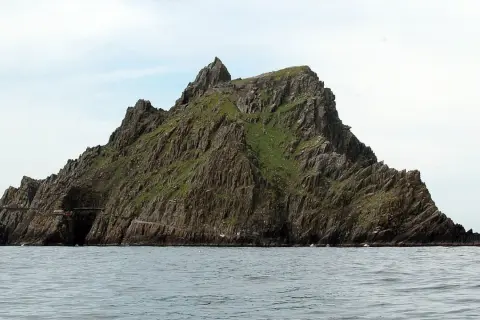 Skellig Michael, zielona, skalista wyspa na oceanie. Planując jak zorganizować logistykę trasy na wyspę Skellig Michael, pamiętaj o trudnym dostępie i zmiennej pogodzie.