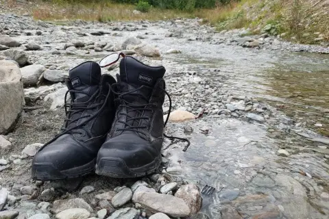 Czarne buty Magnum na kamienistym brzegu potoku. Złe buty na śliskich bazaltach Gór Kaczawskich to gwarancja mokrych stóp i nieprzyjemnych przygód.