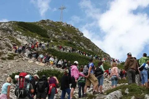 Tłum turystów wspina się na Giewont. Trasa z Kasprowego na Giewont jest długa, ale widok z góry wynagradza wysiłek.