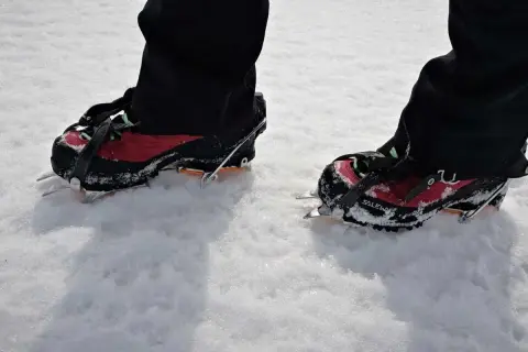 Buty z rakami na śniegu, idealne, by dobrać raczki turystyczne na szlaki w Górach Stołowych.