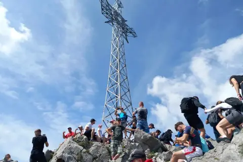 Turyści pod krzyżem na Giewoncie. Zastanawiasz się, ile waży krzyż na Giewoncie? To imponująca konstrukcja!