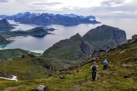 Widok na górzysty archipelag z turystami wędrującymi po zboczu.