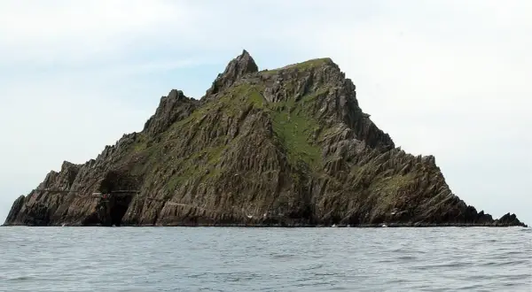 Skellig Michael, zielona, skalista wyspa na oceanie. Planując jak zorganizować logistykę trasy na wyspę Skellig Michael, pamiętaj o trudnym dostępie i zmiennej pogodzie.
