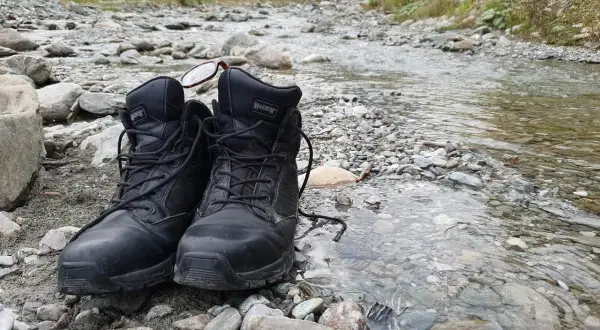 Czarne buty Magnum na kamienistym brzegu potoku. Złe buty na śliskich bazaltach Gór Kaczawskich to gwarancja mokrych stóp i nieprzyjemnych przygód.