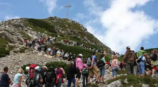 Tłum turystów wspina się na Giewont. Trasa z Kasprowego na Giewont jest długa, ale widok z góry wynagradza wysiłek.