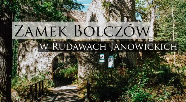 Kamienne ruiny zamku Bolczów w Rudawach Janowickich, porośnięte zielenią, z łukowym wejściem i drewnianym mostkiem.