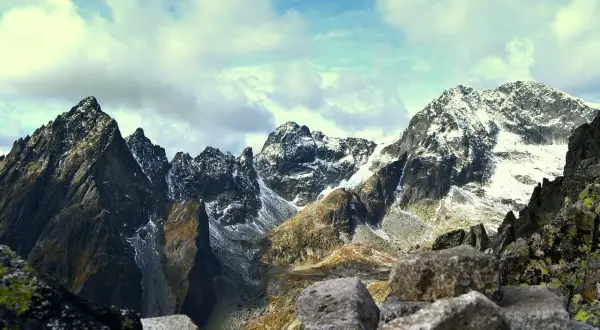 Tatry jesienią: skaliste szczyty, śnieg i chmury. Idealne dla szukających najbezpieczniejszych tras w Tatrach dla osób z lękiem wysokości.