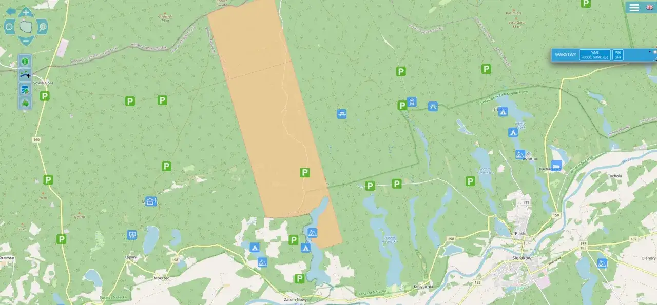Mapa pokazuje tereny leśne z zaznaczonymi parkingami i miejscami biwakowymi. Czy spanie na dziko na trasie jest legalne? Przepisy Lasów Państwowych mogą to regulować.